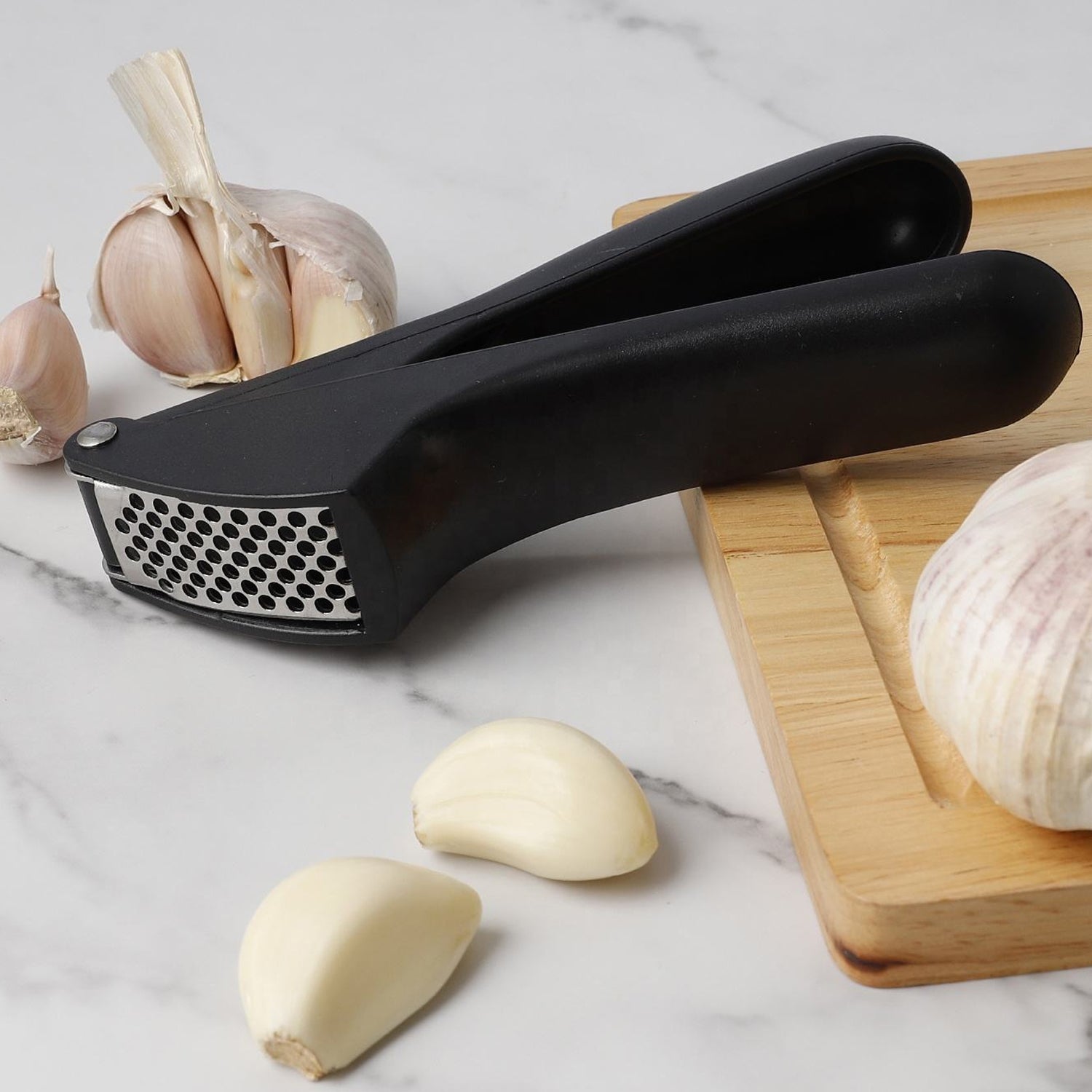Manual garlic press crusher tool placed in modern kitchen setting