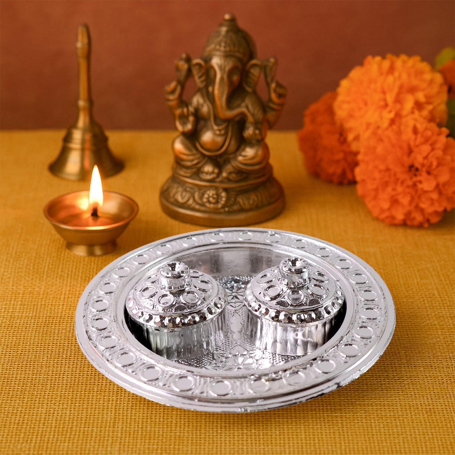 The round Kumkum Thali Holder displayed elegantly on a traditional Indian cloth.