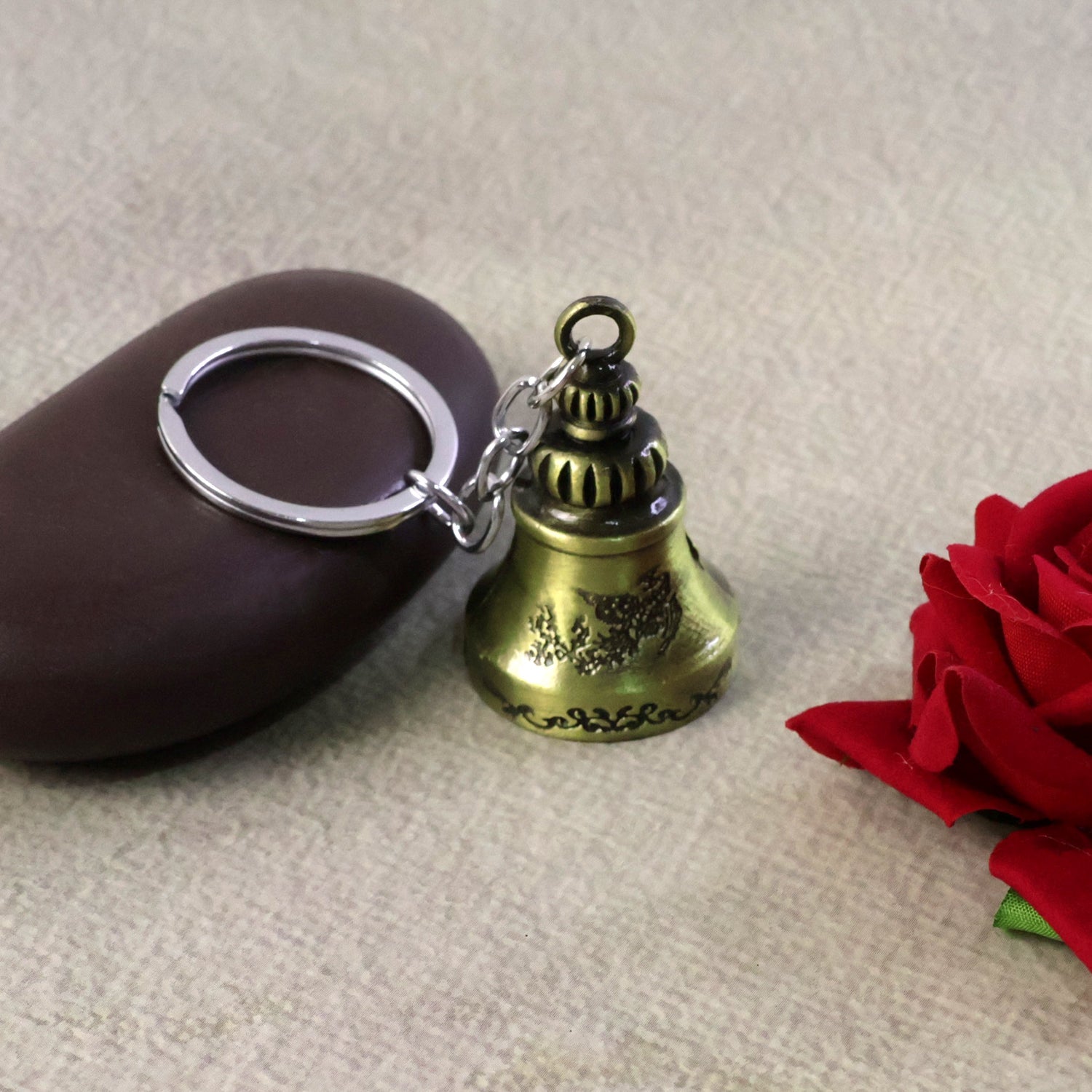 Close-up of a spiritual temple bell keychain crafted from durable metal.