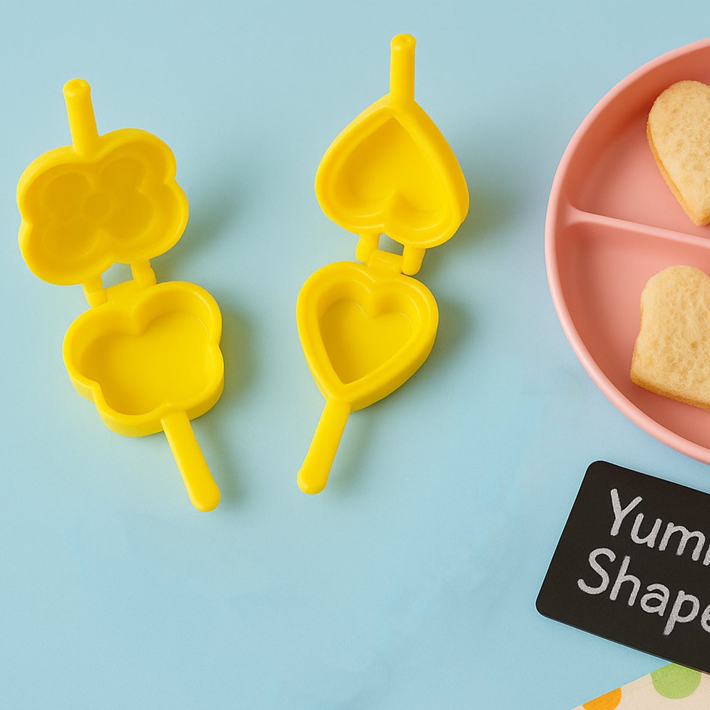 Assorted plastic cookie cutter moulds in bright colours arranged for home baking fun.