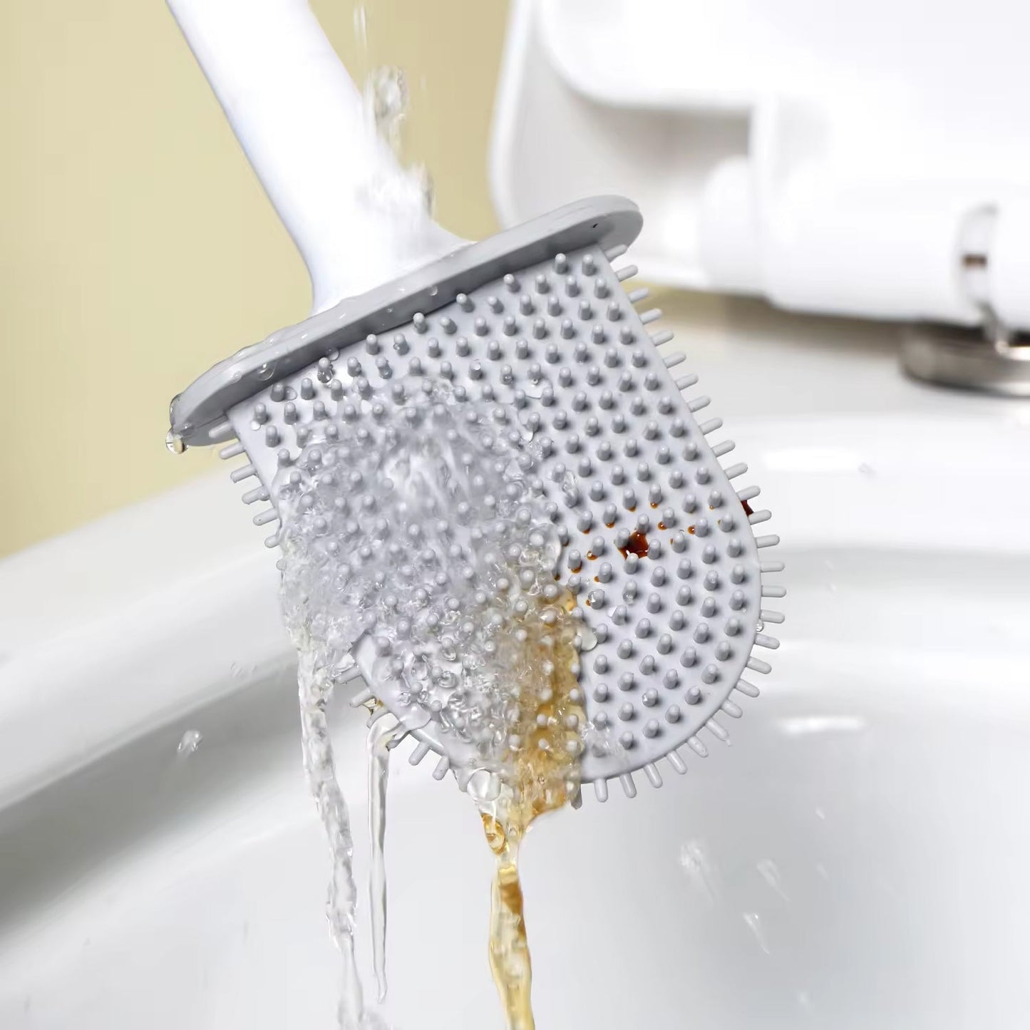 Silicone toilet brush with holder mounted on a clean bathroom wall.