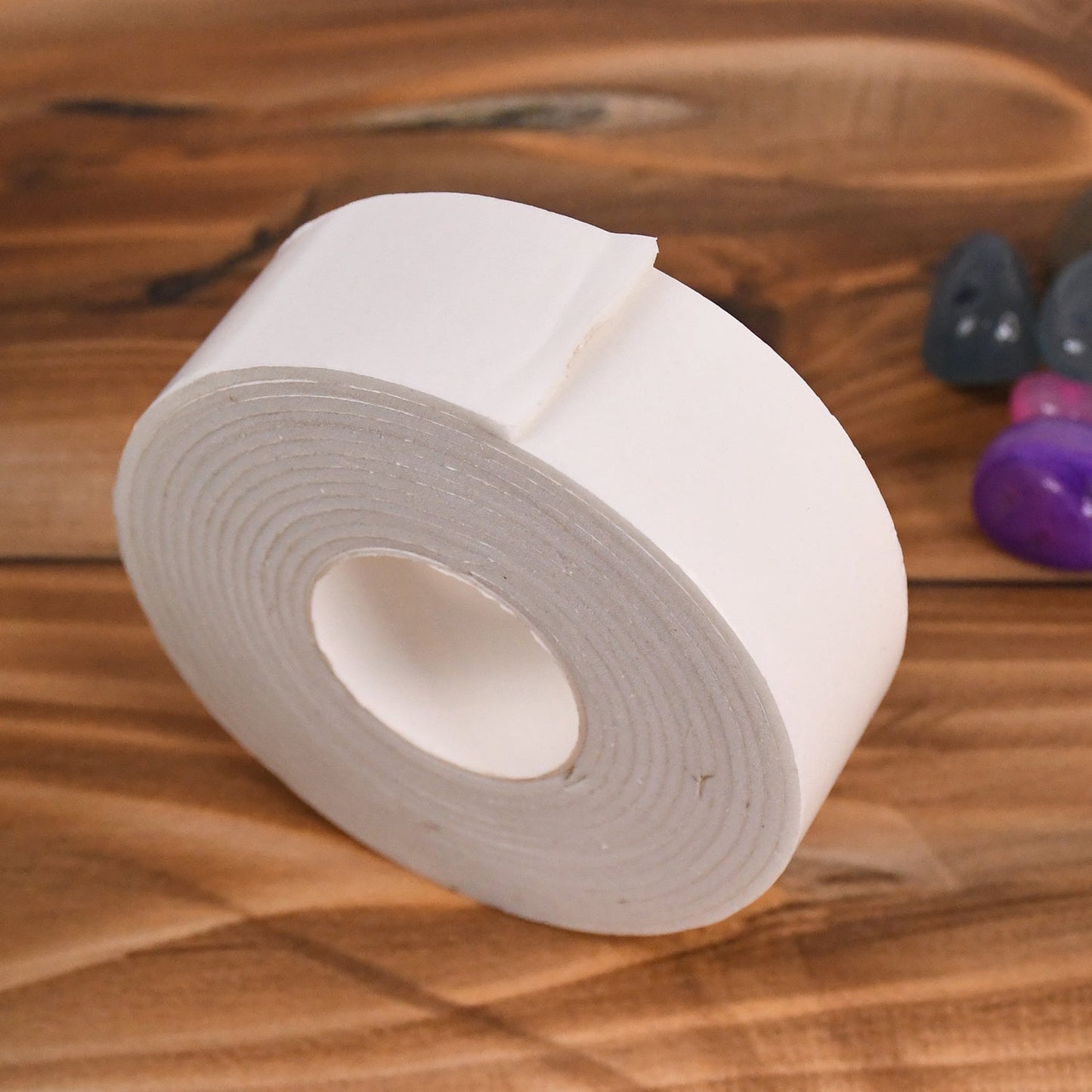 Double sided foam mounting tape firmly securing items on a smooth wall surface.