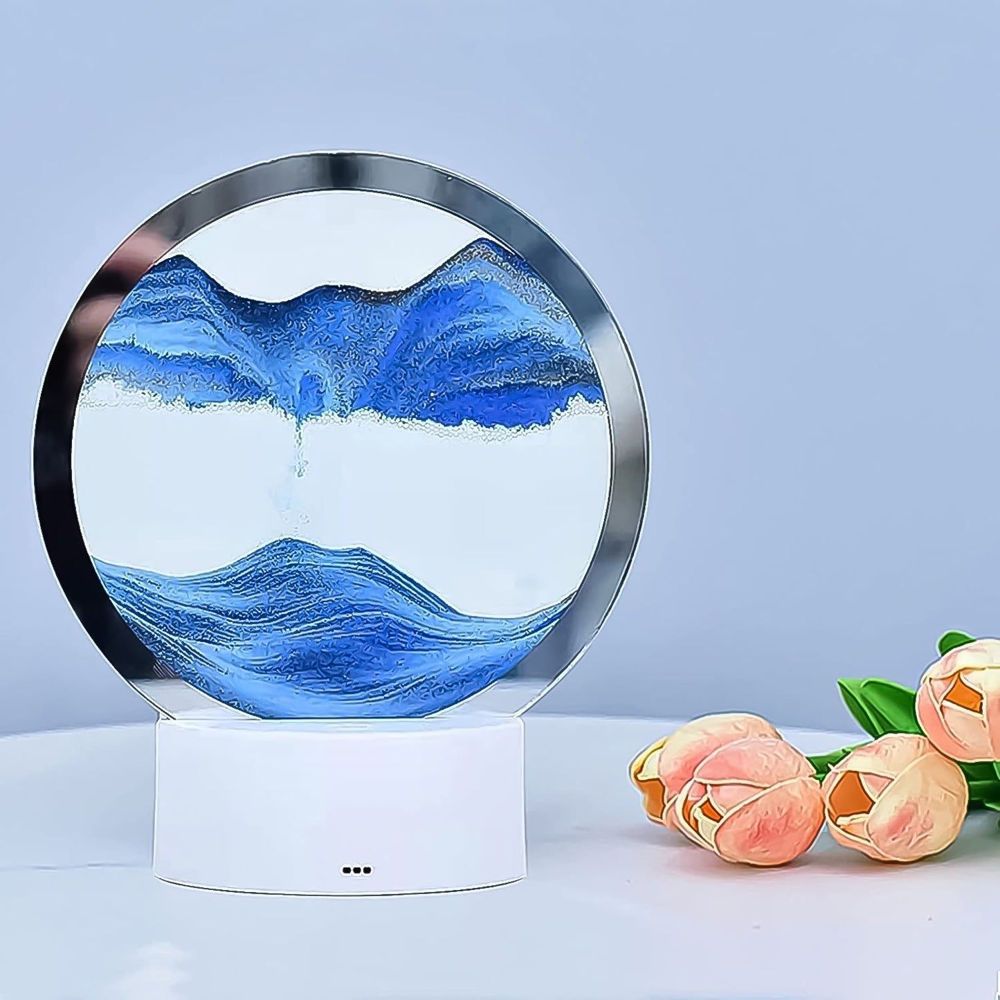 The Moving Sand Art Picture acting as a unique table lamp with its colored light base.