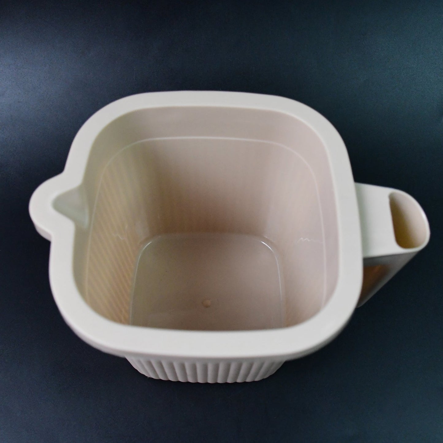 Close-up of a clear Plastic Bath Mug, emphasizing its smooth finish and robust build.
