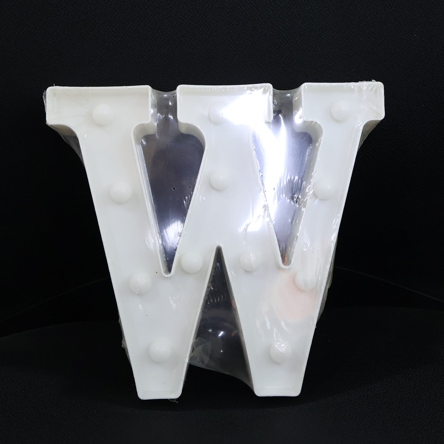 W shaped LED decorative light positioned on shelf as home decor