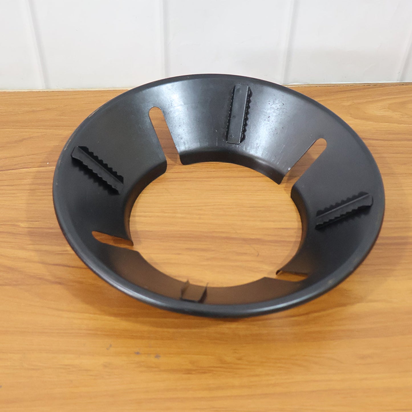 Closeup of flame protector ring on gas stove burner preventing spills