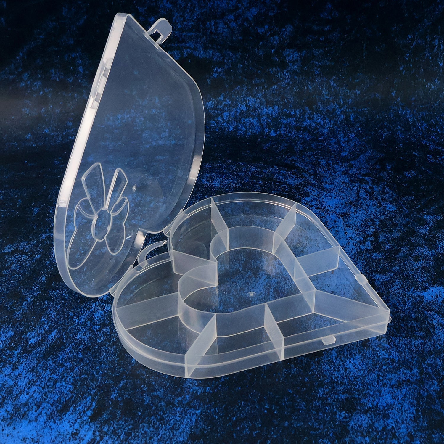 Closed heart-shaped storage box with clear plastic body and decorative bow lid