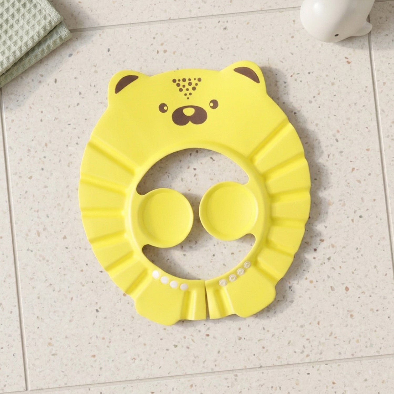 An infant wears a baby bath hair protection hat, made from soft waterproof material for gentle care.