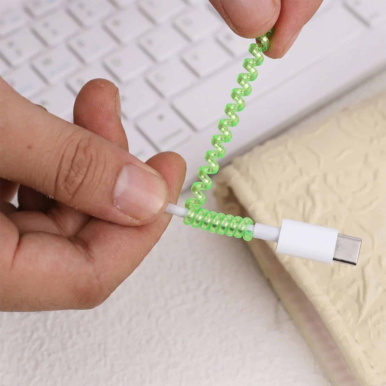 Flexible cord saver wrap in a spiral design protecting a charger cable.